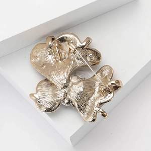Detailed back view of golden iris brooch showing the pin lock and textured metal finish