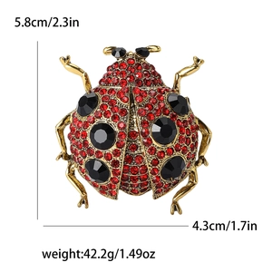 Exquise broche coccinelle dorée avec strass rouges et cristaux noirs pour femmes