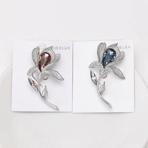 Detailed view of lily brooches with champagne and blue crystals on a display card