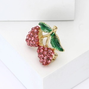 Elegante spilla a fragola dorata con strass rosa e smalto verde su base bianca