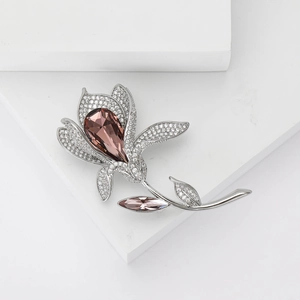 Elegant lily flower brooch with pink zircon and crystals on white geometric stand