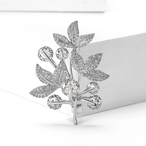 Détail macro d'une broche feuille en argent avec sertissage de zircons micro-pavés