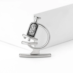 Detailansicht der Mikroskop-Brosche mit glänzenden Straßsteinen und Silber-Finish