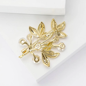 Vue détaillée d'une broche de luxe à trois feuilles avec des pierres de zircone serties