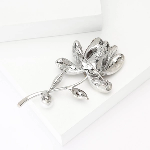 Detail of silver flower brooch back featuring metal snowflake texture and secure pin clasp