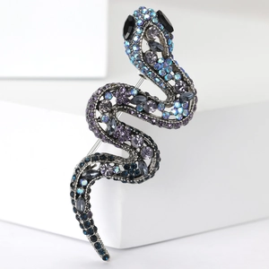 Détail macro d'une broche serpent avec strass dégradés bleus et base en alliage argent