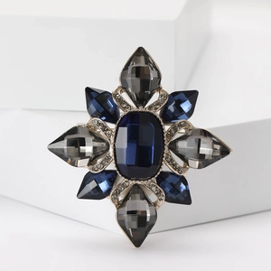 Close-up of Baroque brooch with blue rectangular stone and sparkling teardrop crystals