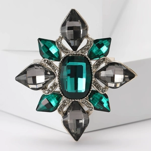 Detailed macro of vintage Baroque brooch with emerald green gemstone and silver rhinestones