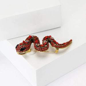 Élégante broche serpent dorée avec strass rouges et yeux en pierres noires précieuses