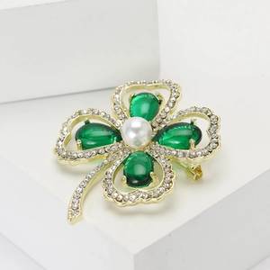 Elegante spilla a quadrifoglio dorata con cristalli verdi e perla su base bianca