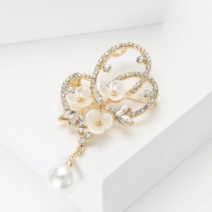 Broche papillon dorée élégante avec fleurs blanches, cristaux et pendentif en perle