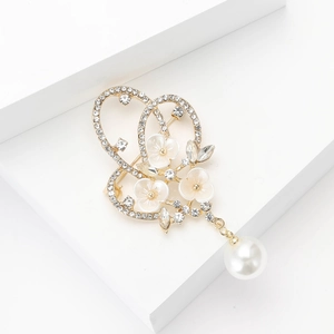 Broche fleur dorée élégante avec strass et perle sur un support géométrique blanc