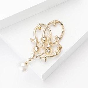 Détail de la broche fleur de prunier dorée avec perles et fixation en épingle métallique
