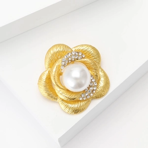 Élégante broche fleur dorée en métal brossé avec perle blanche et strass scintillants