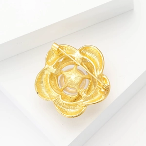 Détail du dos de la broche fleur dorée avec fermoir et incrustation de perles