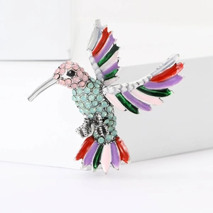 Vue détaillée de la broche colibri avec strass colorés et ailes en émail