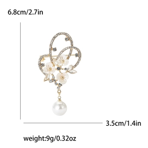 Broche papillon dorée élégante avec fleurs blanches, cristaux et perle suspendue