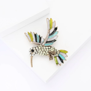 Exquise broche colibri avec ailes en émail coloré et strass étincelants sur base dorée