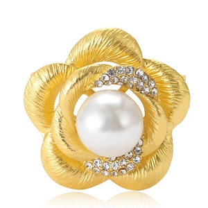 Élégante broche fleur dorée avec perle blanche et cristaux sur fond blanc brillant
