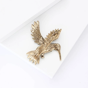 Vue arrière détaillée de la broche colibri dorée montrant l'épingle et le fermoir de sécurité