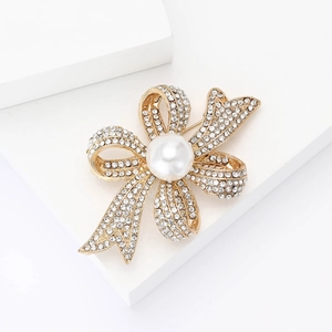 Broche nœud élégante en métal doré avec strass scintillants et perle centrale