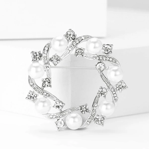 Macro detail of alloy wreath brooch with white pearls and sparkling rhinestones