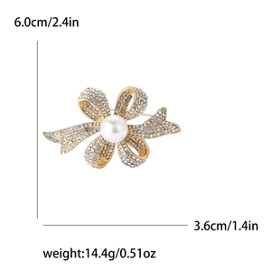 Broche nœud élégante en or avec strass scintillants et perle blanche au centre