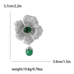 Detail view of flower brooch with green gemstone and zircons, size 5.7cm by 3.9cm