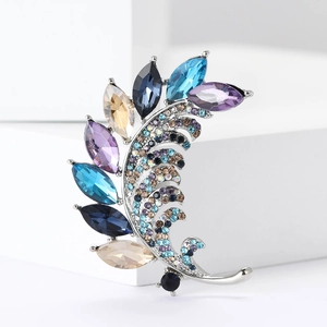 Macro d'une broche en alliage argenté avec cristaux multicolores sur fond épuré