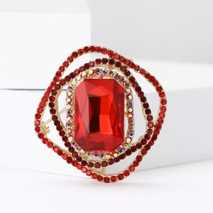 Macro shot of luxury gold brooch with large emerald-cut red stone and crystal halo