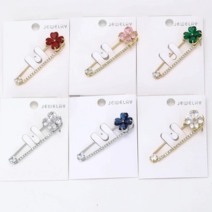 Détail de broches trèfle à quatre feuilles en cristal coloré avec base en métal doré