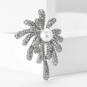 Detailed close-up of a silver rhinestone fireworks brooch with a large white pearl center