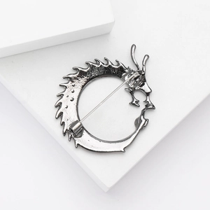 Detailed back view of a dragon brooch showing the secure safety pin clasp and metal texture