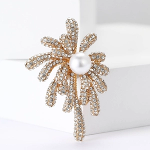 Elegant gold fireworks brooch with pearls and rhinestones on a minimalist white stand