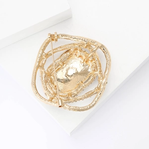 Detailed back view of golden alloy brooch with hammer texture and secure safety pin buckle