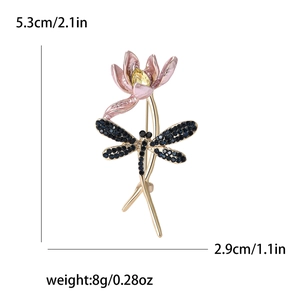 Detailed view of dragonfly brooch with blue crystals and pink gradient flower petals