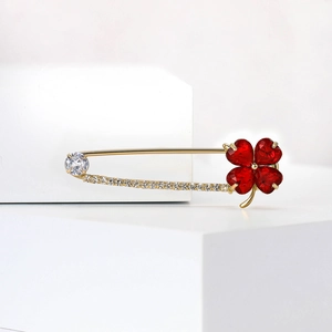 Broche trèfle à quatre feuilles élégante avec cristaux rouges et zircone sur épingle dorée