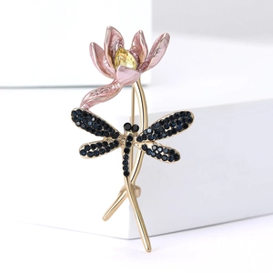 Macro shot of dragonfly lotus brooch with pink petals and blue rhinestones on gold