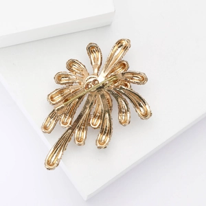 Close-up detail of the secure safety pin fastener on the back of the golden brooch