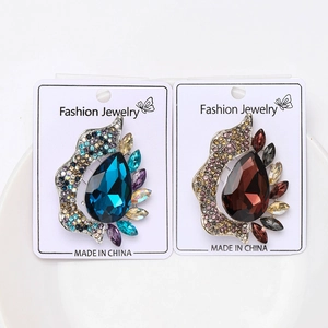Detailed close-up of pear-shaped crystal brooches in deep blue and brown tones