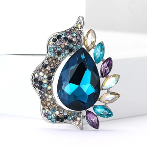 Detailed macro view of vintage silver brooch with large blue pear-cut crystal and rhinestones