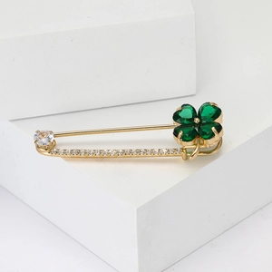 Détail d'une broche en or avec trèfle en cristal vert et pierres de zircon