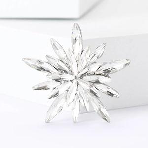 Close-up of a snowflake star brooch with marquise-cut crystals and silver plating