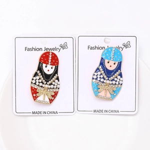 Detailed view of colorful enamel matryoshka brooches with crystals and pearls