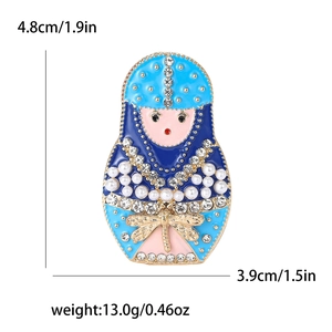 Detailed view of Russian nesting doll brooch with blue enamel and rhinestone wings