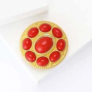 Vintage gold alloy brooch with red rhinestones on a minimalist white display