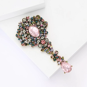 Dettaglio di spilla floreale vintage con cristalli rosa e strass multicolore