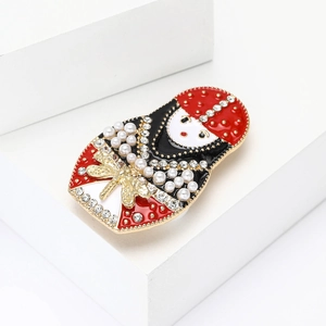 Vintage Russian doll brooch with red enamel, pearls and rhinestones on white display