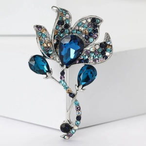 Detail view of silver alloy flower brooch with blue crystals and multicolored rhinestones