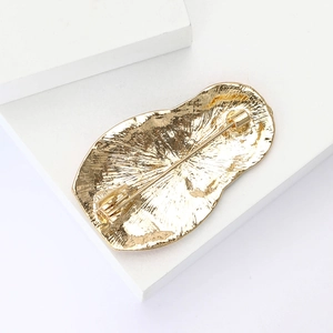 Detail view of the golden metal back and pin clasp on vintage Russian doll brooch